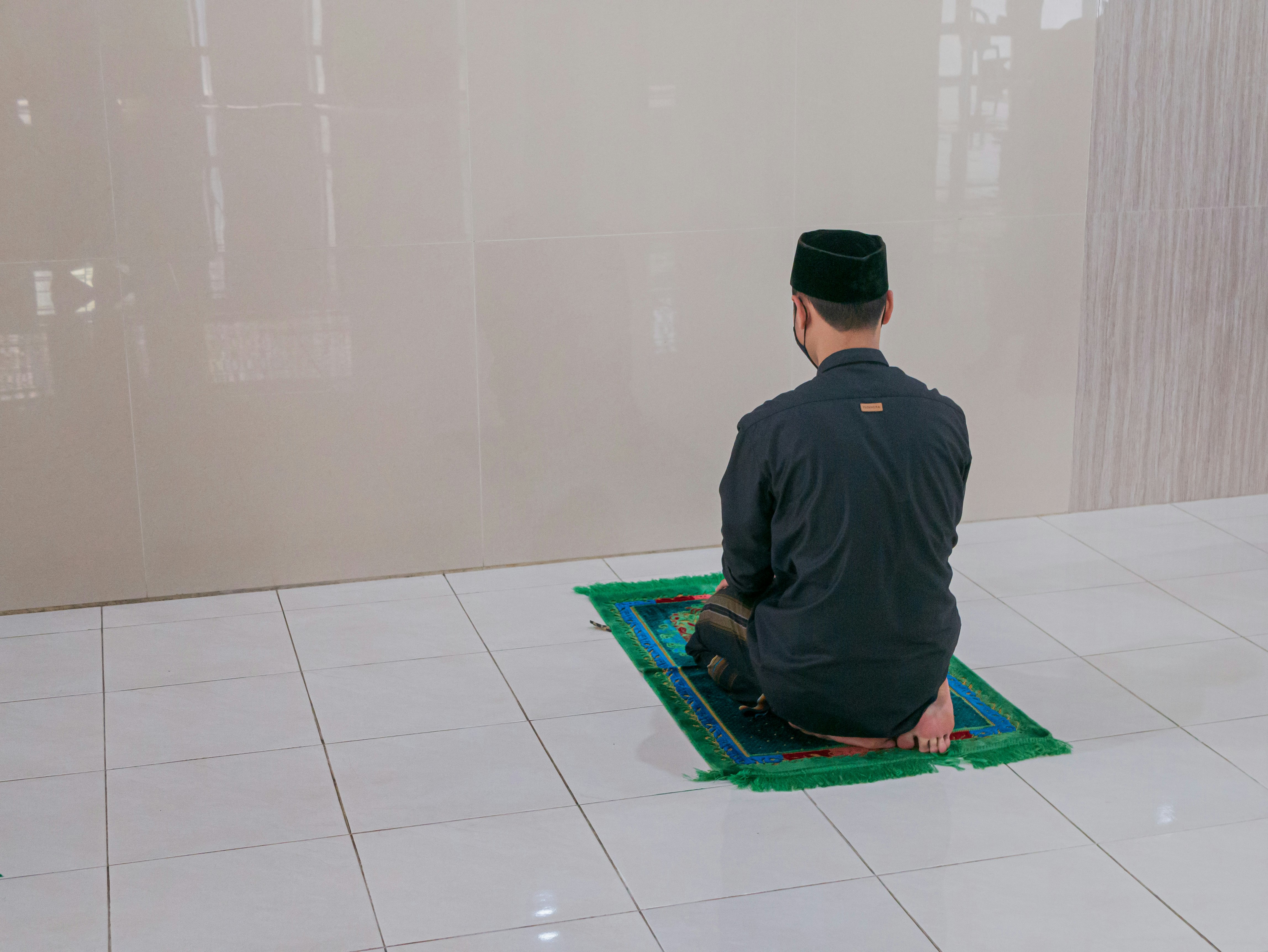 man in black long sleeve shirt sitting on green mat